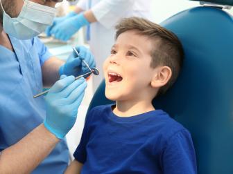 Kleiner Junge lacht während der Prophylaxe