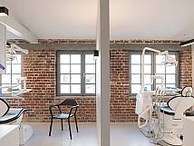 Zwei Behandlungszimmer, getrennt durch eine Wand, mit Backsteinwänden